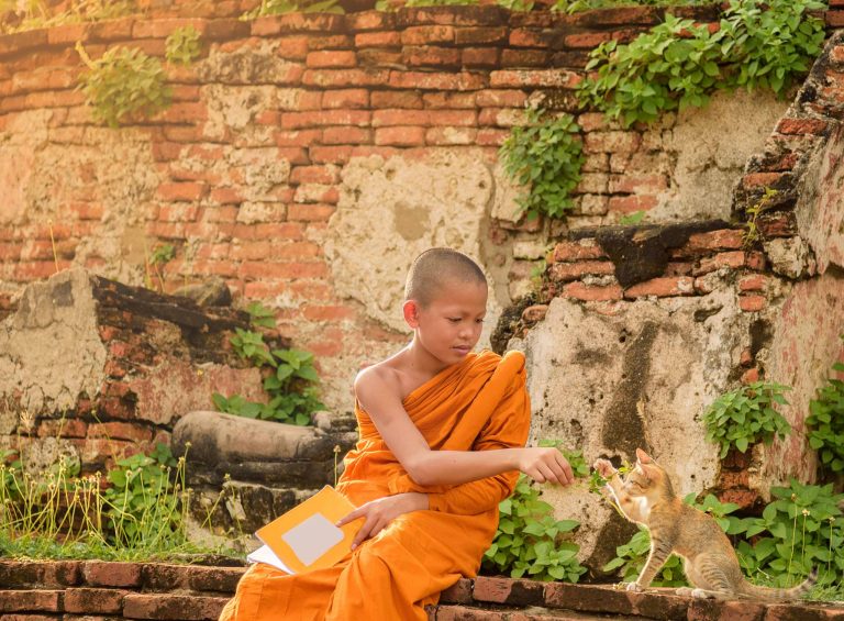 A boy wearing orange in Tibet.