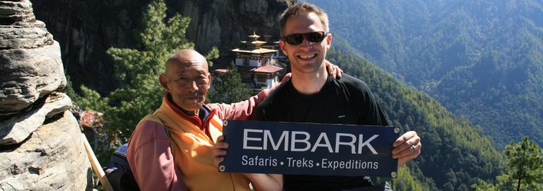 Two hikers in front of a mountain temple in Bhutan