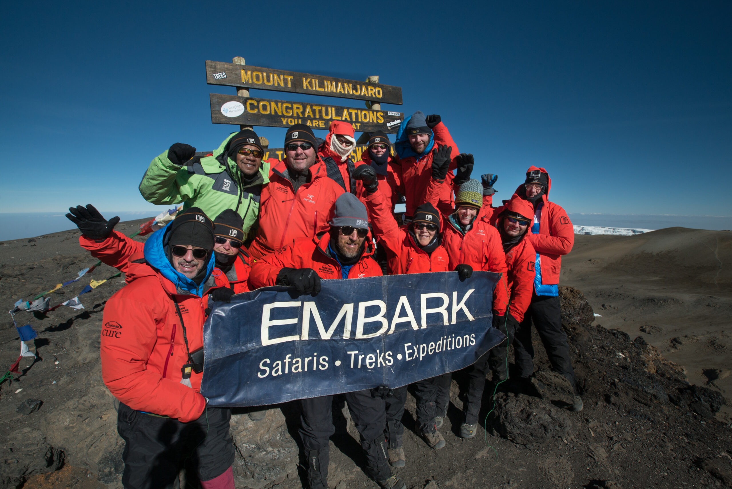 A group of Embark Adventure hikers at the summit of Mt. Kilimanjaro
