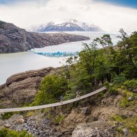 Hikers cross a foot bridge close to one of Patagonia's many glaciers.