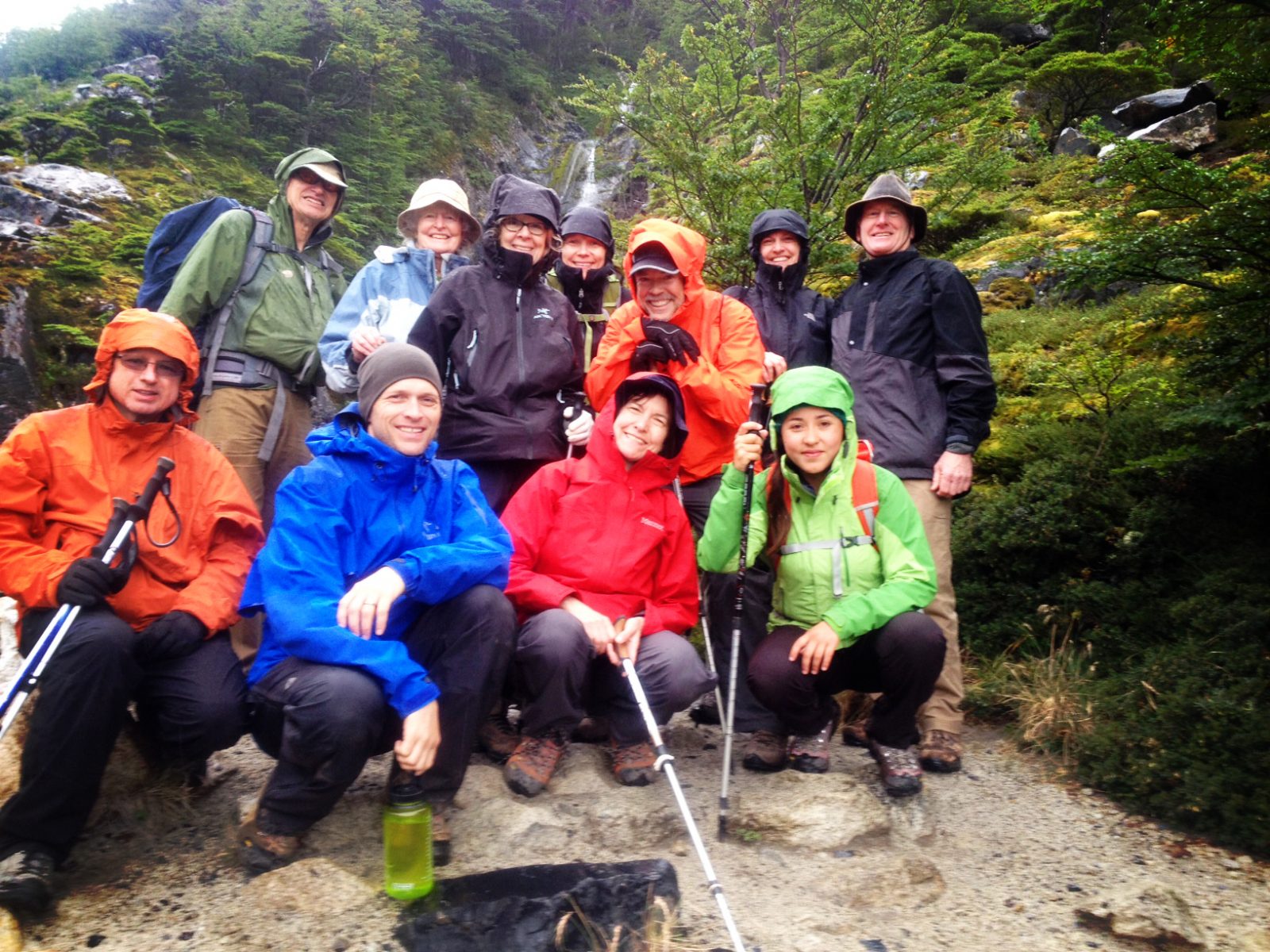 Hikers grouped together for a photo in the rainy forest